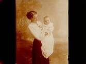 En kvinna med ett litet barn på armen.
Fru Theresia Karlsson