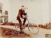 En okänd man på cykel.Bilden tagen kring sekelskiftet.