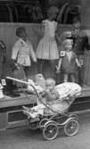 Barnvagnar 10 augusti 1966

En pojke sitter i en barnvagn utanför affären med barnkläder.