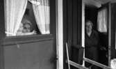 Gyttorp 2 23 februari 1967

En kvinna med glasögon är klädd i rock och tröja står i dörren och tittar ut. Dörren bredvid står en kvinna med ett barn.