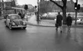 ående, första felgångarn 7 februari 1967Vid Trädgårdstorget går en man med portfölj, och en kvinna över övergångsstället med trafikljus. På Storbron ser man en cyklist och en buss. Längre bort ser man Centralpalatset på Olaigatan.