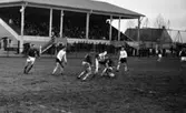 Götberg skall leda idrottsplutonen,
ÖSK - Bäckman 11 april 1967

Fotbollspelare spelar på Trängens fotbollsplan. På läktaren sitter det publik, och nedanför står det mer publik.