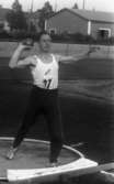 Stig Pettersson 7 juli 1965

Ung idrottsman iklädd vitt sportlinne, mörka gymnastikbyxor samt vita gymnastikskor utövar sporten kulstötning. Han håller en stor kula i sin högra hand. Han håller armen i axelhöjd. Han har nummer 67 på en nummerlapp på magen.