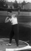 Stig Pettersson 7 juli 1965

Ung idrottsman iklädd vitt gymnastiklinne, mörka gymnastikbyxor samt vita gymnastikskor utövar sporten kulstötning. Han håller kulan med högra handen i halshöjd.