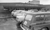 Stormarknaden, 31 juli 1965

Entrén till Domus stormarknad en regnig dag. Bilden är tagen på stormarknadens parkering. Flera bilar är parkerade där. Skyltar med texten 
