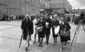 Knytkalaset 5 juli 1965.

En grupp jubileumsdeltagare kommer gående på torget.