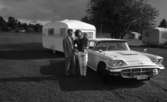 Knytkalaset 5 juli 1965.

Familj bestående av mor, far och liten flicka stående vid bil med husvagn.