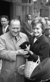 Knytkalaset 5 juli 1965.

Harald Aronsson med en jubileumsvärdinna. De håller gemensamt i en liten kattunge. Åskådare i bakgrunden. En musikers huvud i förgrunden även.