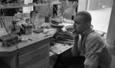 Silversmed 20 augusti 1965
En bild på en silversmed vid sitt arbetsbord. På bordet står en burk med etikett som lyder 
