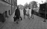 Gentlemen finns de, 15 september 1965

Bildserie: en kvinnlig journalist med flera resväskor testar hjälpsamheten hos medmänniskorna. Här går hon i riktning mot järnvägssationen med sina väskor. På trottoaren går också en kvinna med två ungdomar.
