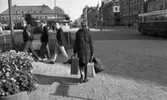 Gentlemen finns de, 15 september 1965

Bildserie: en kvinnlig journalist med flera resväskor testar hjälpsamheten hos medmänniskorna. Här passerar hon busstationen. Tre tonårspojkar passerar framför henne.