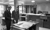 Handelsbanken Fellingsbro 11 december 1965

Två kostymklädda unga män samt en snickare syns på bilden. De båda unga herrarna tittar på en ritning som de har framför sig. Det är inne i Handelsbanken i Fellingsbro. Inredningen är under konstruktion.