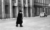 Halkiga pensionärer, 18 december 1965

Två äldre damer -pensionärer-  är på väg över gatan en vinterdag. Den ena damen har en käpp i ena handen samt en handväska i den andra. På huset i bakgrunden finns två skyltar med texten 