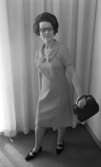 Modebilder 23 april 1966

En mannekäng med kort ljus klänning med rosett vid bysten, en svart handväska i vänster hand, halsband om halsen samt svarta skor med remmar på. Hon bär glasögon.