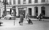 Mopedister 5 maj 1966

En ung pojke åker moped på en gata i centrala Örebro. Han åker förbi en dam i kappa och hatt. Ytterligare personer samt bilar syns på bilden.