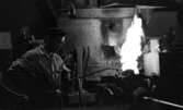 Johnson metall, 21 januari 1966

På bilden i förgrunden åt höger syns en eldslåga och åt vänster en metallarbetare klädd i arbetsoverall, keps, livrem på 