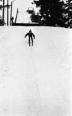 Hoppar i backe 4 mars 1966

Pojke åker nedför snöbacke