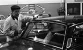 Nytt lyftsystem i bil, Seco-ordföranden 18 februari 1966

I förgrunden syns det en bil med bakfönstren vända mot bildens betraktare. Bakom bilen till vänster står det en man som är klädd i en ljus arbetsrock och en mörk keps.