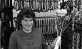 Orubricerat 18 februari 1966

Kvinna med en blombukett i vänstra handen står i en korvfabrik.