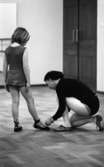Balettskola bildsida 20 januari 1966

Danslärare knyter snöre på flickas balettsko