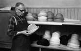 Hattfabrik läggs ned 1 mars 1966

En arbetare på ett hattmakeri håller en randig hatt i sina händer.