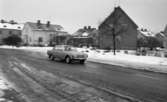 Bilnummer 30 mars 1966

En bil kommer körande på en gata. Det ligger snö på marken.