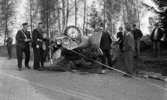 Glanshammar krock, 16 maj 1966

En bil ligger uppochnervänd på en väg. Den är illa tilltygad då den varit med om en krock. Lösa delar av den ligger spridda över vägen. Kring bilen står ett antal personer. Till vänster om den står två poiser samt ytterligare en man. Den ena polisen håller en avspärrningsstolpe med tillhörande rep i sin vänstra hand. Till höger om bilen står fem män och en kvinna. I bakgrunden till vänster står ytterligare en man och betraktar scenariot.













































































































































































or. Han går nedför en kort trappa utomhus.