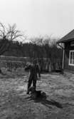 Hundarna i Mosås 4 maj 1966

En stor schäfer ligger ned framför en man klädd i skjorta, slips, kostym, skor och glasögon. Till höger syns ett hus och i bakgrunden åkermark.




























































































































































































































































































or. Han går nedför en kort trappa utomhus.
