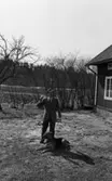 Hundarna i Mosås 4 maj 1966

En stor schäfer ligger ned framför en man klädd i skjorta, slips, kostym, skor och glasögon. Till höger syns ett hus och i bakgrunden åkermark.




























































































































































































































































































or. Han går nedför en kort trappa utomhus.