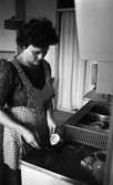 Oddjobb, Hemsamarit 3 september 1965

En hemsamarit lagar mat vid spisen i ett kök.