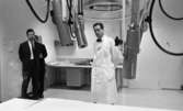Regionsjukhuset 25 november 1965

En läkare i vit rock samt två andra herrar i svarta kostymer befinner sig i ett rum med medicinsk utrustning på Regionsjukhuset i Örebro.