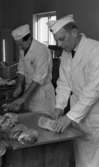 Från gris till skinka. Slakthuset 11 februari 1965.

Två män arbetar med livsmedelstillverkning.
Närmast på bilden är Evert Wing.