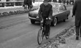 Dragos cyklar 28 januari 1966

En man cyklar klädd i rock och byxor genom centrala Örebro. Bakom honom kör en man i kostym i en personbil. Till höger syns en man klädd i rock och byxor som går trottoaren fram med ryggen åt kameran. På andra sidan gatan går flera fotgängare på trottoaren. En kvinna med barnvagn syns i bakgrunden.