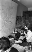 Taxi, 14 februari 1966

Två kvinnor sitter i en ledningscentral på Taxi. En karta hänger på väggen.