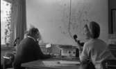 Taxi, 14 februari 1966

Två kvinnor sitter i en ledningscentral på Taxi. En karta sitter på väggen.