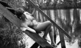 Baddräkter, Hus forts. 30 juni 1966

En fotomodell klädd i bikini med ett mönster med små stjärnor på ligger på en trappa som leder ner i ett vattendrag. I öronen har hon stora örhängen.