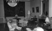 Kräftor- Karlslundsgård 5 aug. 1967

Ett rum på Karlslunds Herrgård med en soffa, fåtöljer, bord och stolar bl.a. En stor bonad hänger på väggen bakom soffan. En stor spegel hänger över den öppna spisen till höger och en kristallkrona hänger i taket. Mattor ligger på golvet.