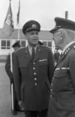 Kungen I3 28 augusti 1967

Kung Gustav VI Adolf besöker Örebro Livregementes Grenadjärer i Grenadjärsstaden. Ett antal män står uppställlda på regementsgården klädda i militäruniformer liksom kungen. Den sistnämnde står och samtalar med en general. I bakgrunden står två andra mlitärer varav den ene har en befälsbricka runt halsen samt en håller en fana i handen. Andra personer syns i bakgrunden.