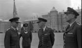 Kungen I3 28 augusti 1967

Kung Gustav VI Adolf besöker Örebro Livregementes Grenadjärer i Grenadjärsstaden. Tre andra män står uppställlda på regementsgården klädda i militäruniformer liksom kungen. En av militärerna har en befälsbricka runt halsen och en fana i handen.