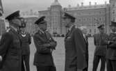 Kungen I3 28 augusti 1967

Kung Gustav VI Adolf besöker Örebro Livregementes Grenadjärer i Grenadjärsstaden. Flera män står uppställlda på regementsgården klädda i militäruniformer liksom kungen. En av militärerna har en befälsbricka runt halsen och en fana i handen. En man klädd i mörk kostym, vit skjorta och ljus slips står också bland dem.