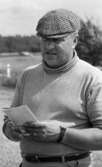 Orubricerad 5 augusti 1967 Travkusk Bengt Nilsson

Travkusken Bengt Nilsson står på en gårdsplan med ett block i sina händer. Han är klädd i rutig keps och ljus tröja.