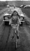 Oscaria test, Skolornas riksfinal, Smyckar holmens skola 12 maj 1967En flicka i tioårsåldern kommer cyklande på en väg. Hon är kläd i ljust, rutig kavaj, ljusa byxor, svarta skor och håret i pippilottor. Bakom henne kommer en bil körande där det sitter två polismän.