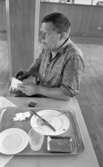 Kembels slutar, Blå stjärnan, 8 juli 1967
En man sitter vid ett bord och plockar med en påse med tobak. Han är klädd i en ljus skjorta. En bricka står framför honom på bordet. På denna står en tallrik, bestick, en uppläggningsfat i metall, en assiett, en använd servett och ett glas. På bordet ligger även en tändsticksask.