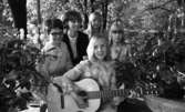 Kommunalmän Wadköping, Bäste amatören 5 juni 1967

Tre flickor och två vuxna kvinnor. En av flickorna sitter framför gruppen med en gitarr i sina händer. Hon är klädd i en långärmad klänning med volanger och bubbelmönster. En av de vuxna kvinnorna bär glasögon.