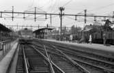Frövi 2 juni 1967

Frövi järnvägsstation. På perrongen står ett antal personer och några sitter på bänkar bl. a. damer i kappor och herrar i kostymer. Två tåg syns på bilden.