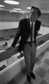 Fångvårdsdirektör Kumla 13 juli 1967

En fångvårdsdirektör i Kumla står inne i fängelset vid ett räcke på andra våningen. Han är klädd i mörk kavaj, mörk slips, vit skjorta, ljusa byxor och mörk livrem. Nere på första våningen i bakgrunden syns bord, stolar och utställningsmontrar.