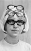 Glasögon 28 juli 1967

Närbild på en ljushårig kvinna med pagefrisyr. Hon har tre par glasögon och en vit tröja på sig samt vita pärlörhängen. Ett par glasögon sitter i hennes ansikte och två upptill på hjässan.