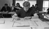 Mekanförbundet, 31 maj 1968

En ung man sitter vid ett bord och skriver på Mekanförbundet. Han sitter med ritningar och skriver på ett papper och gör matematiska beräkningar. Han går en mekanikerutbildning. Han är klädd i en kortärmad tröja. Bakom honom sitter andra personer och skriver vid andra bord.