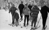 Ånnaboda 12 februari 1968

En grupp personer bestående av ett barn och ett antal vuxna är på skidutflykt i Ånnaboda. De är klädda i jackor, byxor, mössor, vantar och pjäxor. De har skidor på fötterna och stavar i händerna.