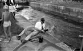 Hjälmaren filmas 19 juli 1967

Fotograf justerar kameran. En båt syns i bakgrunden.
Medarbetare med bandspelare kommer gående.